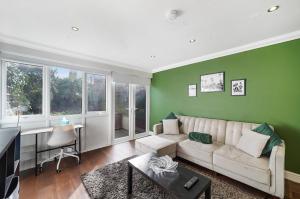 伦敦Stylish 3 BR House close to Streatham Hill station的客厅设有白色沙发和绿色墙壁。