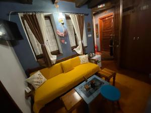 帕莱斯潘蒂雷蒙Traditional Guesthouse Erato的客厅配有黄色的沙发和桌子
