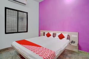 MotīhāriOYO Flagship 81389 Hotel Siddhi Vinayak的一间卧室配有一张紫色墙壁的床
