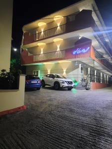 纳夫普利翁Hotel Vasilis的夜间停在大楼前的汽车
