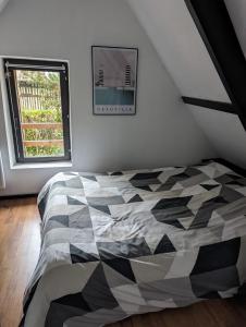 Livarotcharmante maison Normande的卧室设有黑白床和窗户。