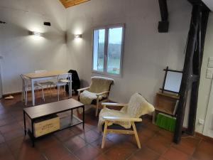 巴讷贡Cottage du Diot, son lac et son île的配有桌椅和窗户的房间