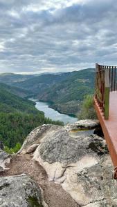 PegarinhosCasa da Oliveira的坐在山顶上俯瞰湖泊的长凳