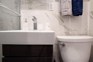 纽约69-3A Prime LES Modern Brand New 1BR的白色的浴室设有水槽和卫生间。