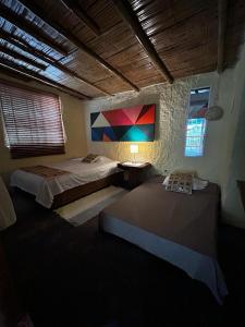 伊瓦格Cabaña Canto de las Aguas Cañón del Combeima的一间卧室设有两张床,墙上挂着一幅画