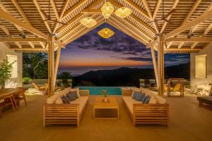 DominicalitoCasa Frenchie Luxury Oceanview Jungle Villa for 12 people的天井配有沙发、桌子和桌子