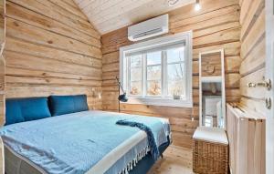 JægersprisBeautiful Home In Jgerspris With Wifi的木制客房内的一间卧室,配有一张床