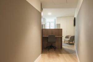 里斯本Apto Ribeira Lisboa的走廊上设有一张桌子和一把椅子的办公室