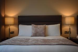 基拉尼The Birches Killarney的一张带白色枕头的床和两盏灯