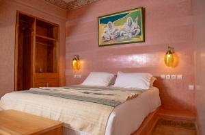 Oulad BarrehilPalais Riad Hida的卧室配有一张带粉红色墙壁的大床