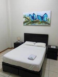 塔拉波托Residencial Brest Amazon Tarapoto的一间卧室配有一张床和蝴蝶画