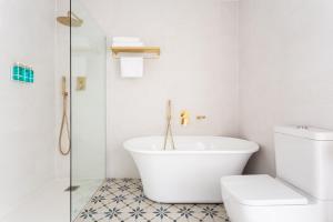 锡切斯Divino Hotel Boutique的白色的浴室设有浴缸和卫生间。