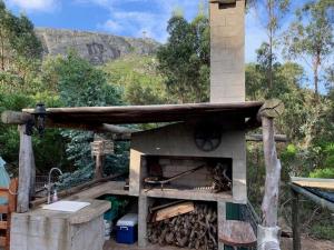 皮里亚波利斯达米罗乡村民宿的一个带木屋顶的户外比萨饼烤箱