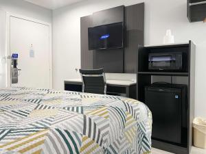 莫罗贝莫罗贝6号汽车旅馆的一间卧室配有一张床、一台电视和一张书桌