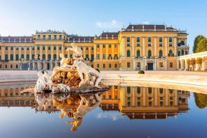 维也纳Quality Hotel Vienna的一座建筑,前面的水里有一雕像