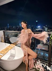 吉隆坡Skyscraper 65 KL Highest Outdoor Bathtub Luxury Lavish Designer Suite Penthouse Lv65的站在建筑物顶上的女装