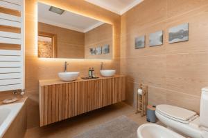科英布拉Confluentia H&A - XIII Century Loft House的浴室配有2个盥洗盆、卫生间和浴缸。