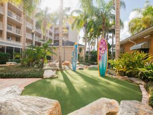 卡纳维拉尔角Holiday Inn Club Vacations Cape Canaveral Beach Resort的建筑前人工草坪上的三个冲浪板