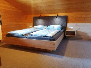 弗拉绍Steinerbauer的小屋内一间卧室,配有一张大木床
