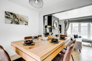 柯比Modern Warm 4 Bedroom House的一间带木桌和椅子的用餐室