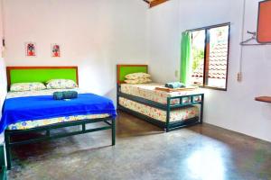 日惹Sonosewu Guesthouse Syariah的一间卧室设有两张单人床和一个窗户。