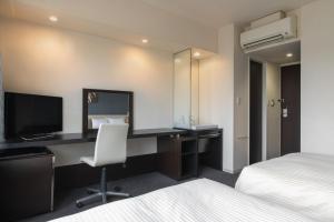 大洲熊本机场维斯塔酒店的酒店客房配有书桌和电视。