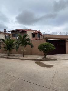 圣克鲁斯Casa bonita y cómoda的车道前有棕榈树的房子