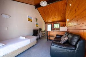 奥雷瓦Orewa Motor Lodge的一间卧室配有一张床、一张沙发和一张书桌