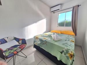 萨尔瓦多Mar.4: above-store with balcony near Airport and Stella Maris beach的卧室配有床、椅子和窗户。