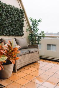 贝尔康嫩Lakeside 3-Bed Apartment with Jacuzzi的藤椅,坐在种有植物的庭院