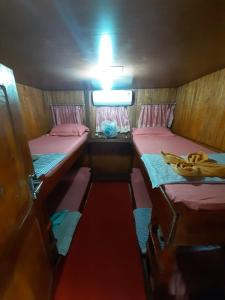 纳闽巴霍Open Trip Komodo 3D2N的小房间,带两张床和一碗香蕉