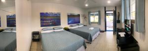 叶盘Island Hopper的一间卧室设有两张床,墙上挂有绘画作品