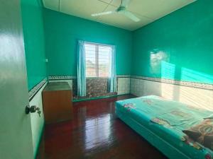 古打毛律House no 39的绿色的客房设有床和窗户。
