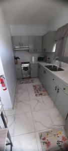 普罗维登西亚莱斯岛Cozyhideaway的白色的厨房设有水槽和炉灶。