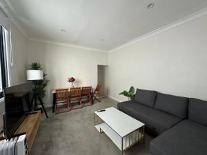 悉尼Dynamic 2 Bedroom home close to city buzz Darling St 2 E-Bikes Included的客厅配有沙发和桌子
