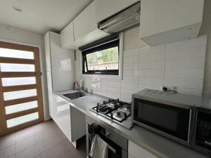 悉尼Dynamic 2 Bedroom home close to city buzz Darling St 2 E-Bikes Included的厨房配有炉灶、水槽和窗户。