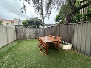 悉尼Dynamic 2 Bedroom home close to city buzz Darling St 2 E-Bikes Included的围栏旁的一张木桌和椅子
