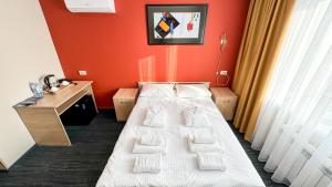 科克舍套Отель KOKSHETAU的酒店客房,设有床铺和红色的墙壁