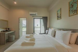 普吉镇Ang Pao Hotel - SHA Extra Plus的一张白色大床,配有白色床单和枕头