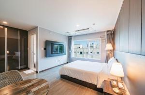 西归浦市Jin Motel的一间卧室配有一张床、一张桌子和一台电视。
