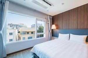 西归浦市Jin Motel的一间卧室设有一张床和一个大窗户