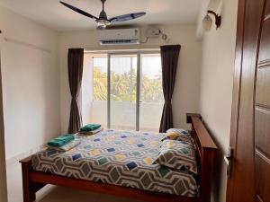 门格洛尔Nirvana Stay, Spacious Fully furnished 2bhk apartment in Mangalore, Full AC的卧室在窗户前配有一张床