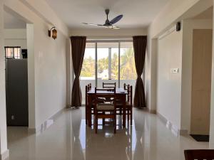 门格洛尔Nirvana Stay, Spacious Fully furnished 2bhk apartment in Mangalore, Full AC的一间带桌椅和窗户的用餐室