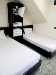 亚美尼亚Casa Quindio的配有白色床单的客房内的两张床