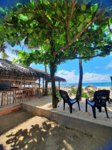 希克杜沃La-Vira Beach Villa的两个黑长椅坐在海滩附近的人行道上