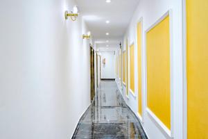 孟买Hotel Gorrion的走廊设有瓷砖地板和黄色墙壁