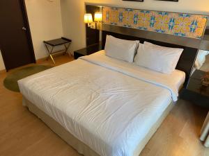 吉隆坡Studio Suite Ceylon Bukit Bintang 09的一间卧室配有一张带白色床单的大床