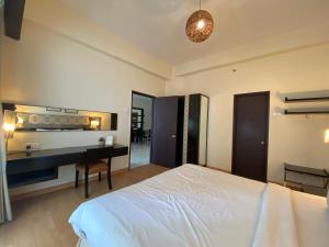 吉隆坡Studio Suite Ceylon Bukit Bintang 09的一间卧室配有一张床、一张桌子和一张桌子