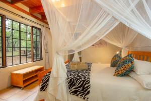 玛洛斯帕克Marloth Kruger Little Manor的一间卧室配有一张带蚊帐的床