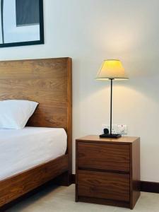 库鲁内格勒Lake Round Luxury House的一间卧室配有一张床,床头柜上配有一盏灯
